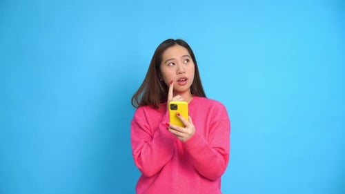 Woman with Smartphone Thinks on Blue Background