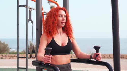 Sporty Woman Practising Abdominal Crunches on Equipment at Outdoor Gym