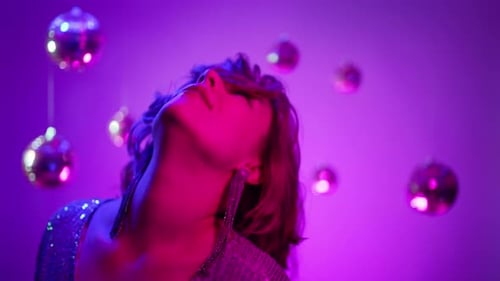 Young Sexy Glamorous Woman Dancing Alone in Dark Studio with Neon Colorful Light