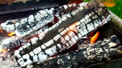 Embers burn in a grill, ready for cooking