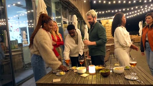 Friends Toasting Standing on a Bar Terrace at Night