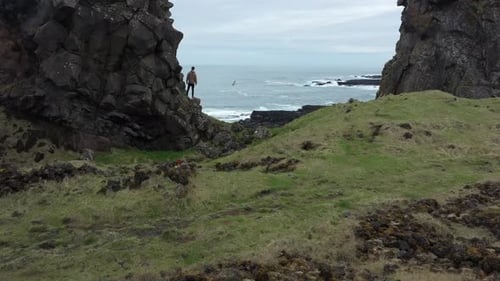 Explorador observando a costa acidentada da Islândia