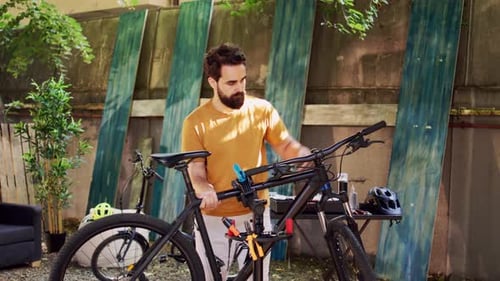 Man Moving Bicycle to Repairstand