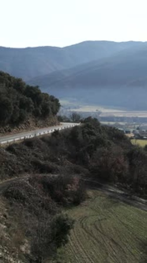 A Biker Crossing a Road in the Wilderness