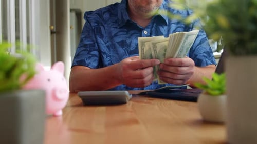 Close Up Of Male Hands Managing Cash On Kitchen Table In Sunlit Room