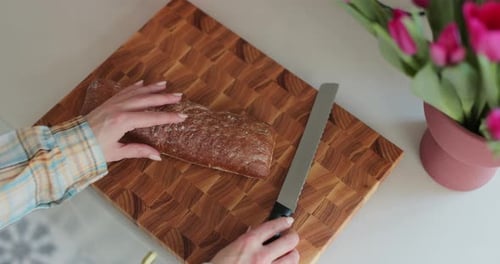 Woman Cutting Bread on Wooden Cutting Board