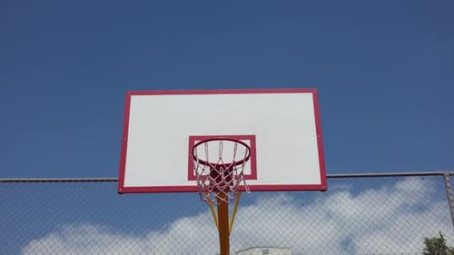 Hand eines sportlichen Mannes, der während eines Spiels im Freien Basketball in Richtung Korb wirft