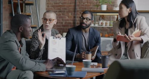 Business Professionals Discussing Charts and Graphs at Meeting