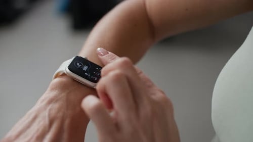 Sportswoman Checking Smartwatch Fitness Data and Heart Rate in Gym