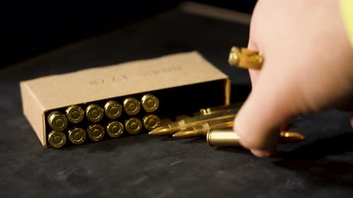 Hand Picking Up Golden Bullets Close Up