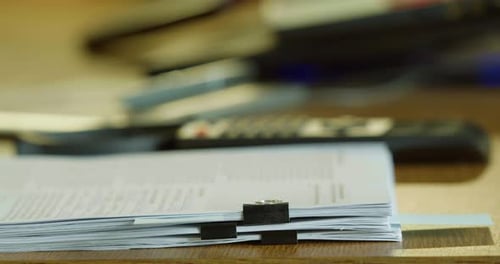 Human Dropping a Stack of Sheets on a Desk at the Office