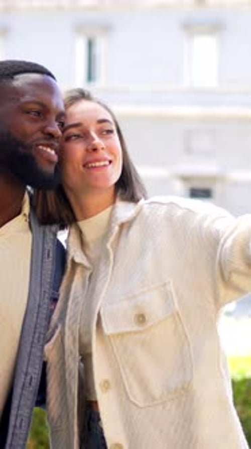 Casal multiétnico abraçado para tirar selfie no mirante da cidade