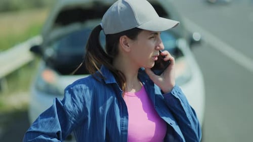 Woman Talking on Phone Next to Broken Down Car