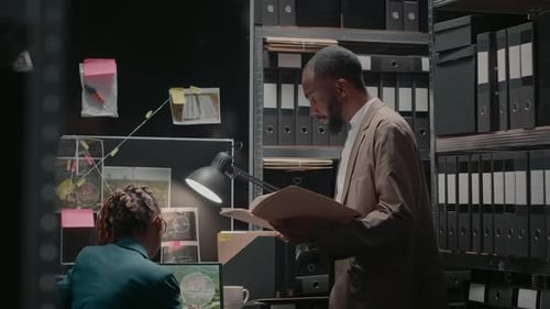 Two Colleagues Reviewing Files in Office