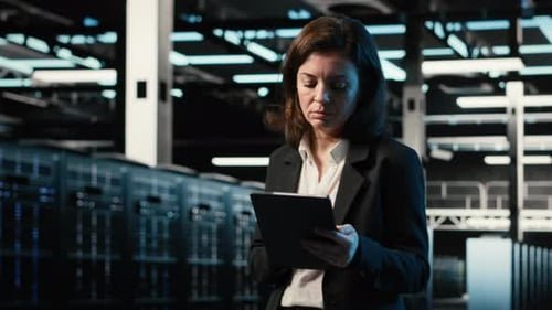 Engineer Walking in Data Center Monitoring Automation Systems Using Tablet