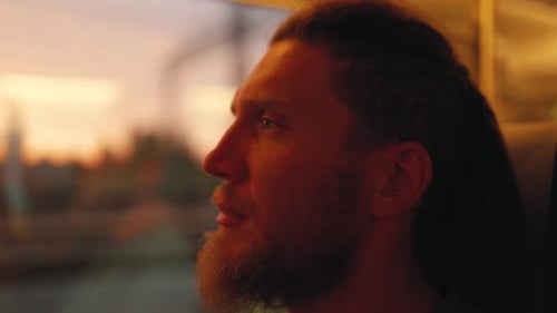 Un homme voyageant en train regarde par la fenêtre