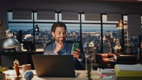 Man Using Smartphone in Modern Office at Night