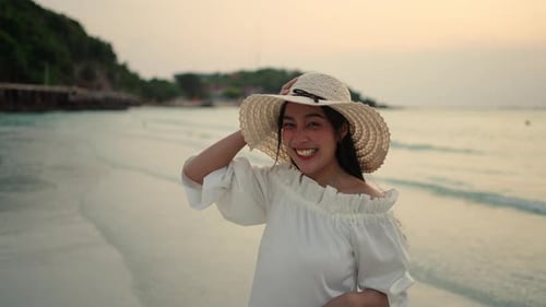 4K Portrait of Asian woman walking on tropical island beach at summer sunset