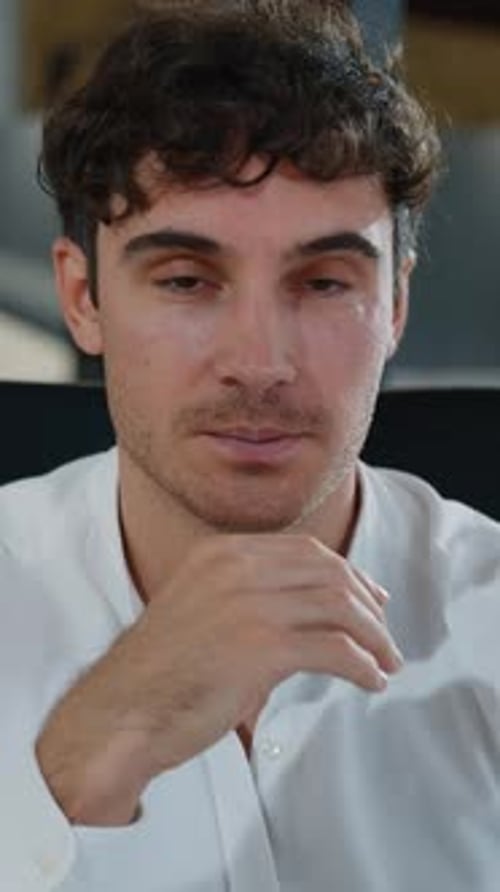 Young Adult Man Smiles Confidently at Camera Indoors