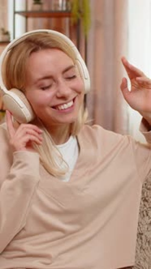 Woman Wearing Headphones Listening to Music and Dancing