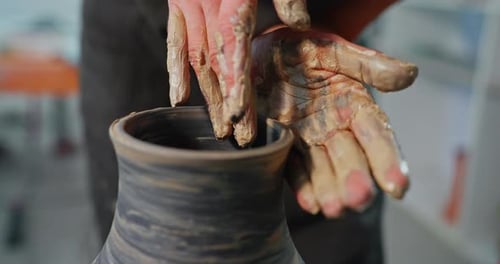 Close Up of Potter's Hands Shaping Clay Vase