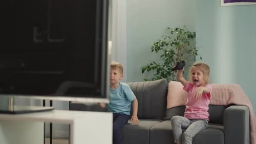 Girl Feels Happy to Beat Little Brother Playing Video Game