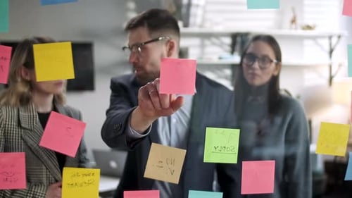 Office Team Collaborates with Sticky Notes on Glass