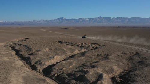 Cinematic and tracking drone shot of a car traveling the Charyn Canyon in Kazakhstan