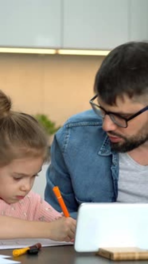 Padre e hija pequeña aprenden a dibujar viendo una lección de dibujo en Internet