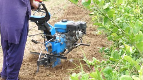 Pakistani Farmer Pushing Petrol Tiller Cultivator Over Soil In Sindh, Pakistan. Slow Motion