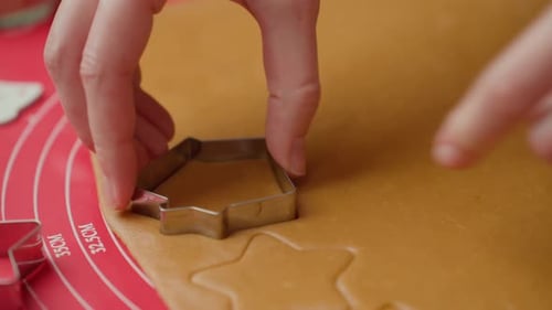 Hands Cutting Out Festive Sugar Cookies
