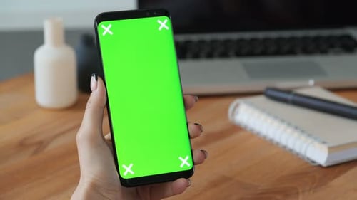 Person, die ein Handy mit Greenscreen-Display in der Hand benutzt, und Frau machen eine Geste. Nahaufnahme Conce...