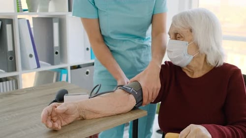 Nurse Takes Blood Pressure of Senior Woman