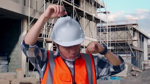 Close Up Of Asian Male Engineer Screaming Goal And Dancing Celebrating At Building Site