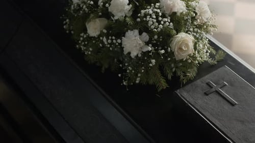 Coffin Lid with White Flowers and Holy Bible at Funeral Ceremony