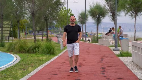 Young man walking on jogging track 4K