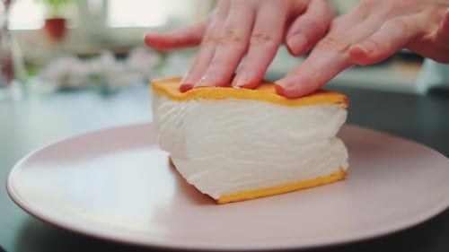 Hands Preparing a Dessert Sandwich on Pink Plate