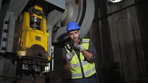 Engineer is working at machine part factory.