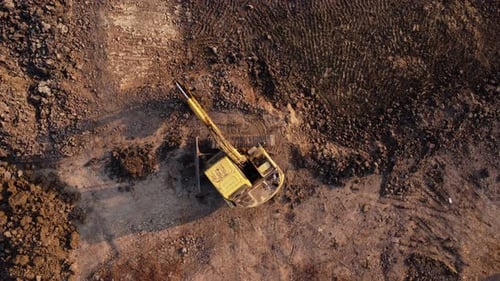 Excavator dig ground at construction site. Aerial view of a wheel loader excavator with a backhoe