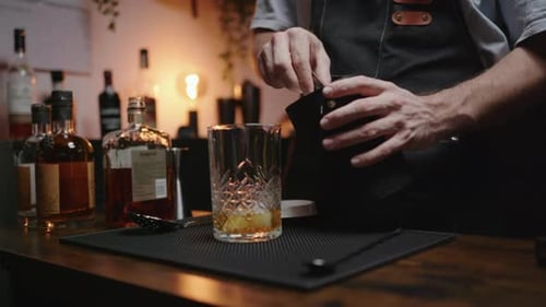 Bartender Adding Ice to Cocktail Drink at Bar