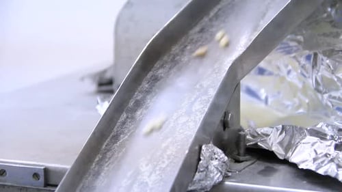 White pills moving on metal automatic line in workshop of pharmaceutical factory