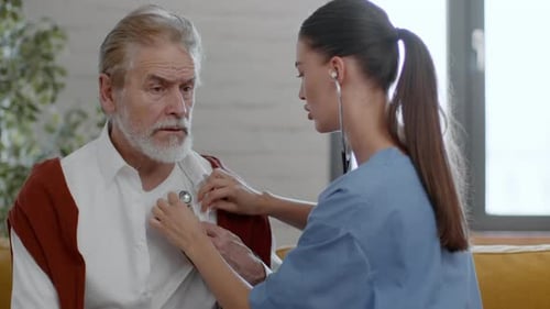Doctor Listens to Senior Man's Heart with Stethoscope