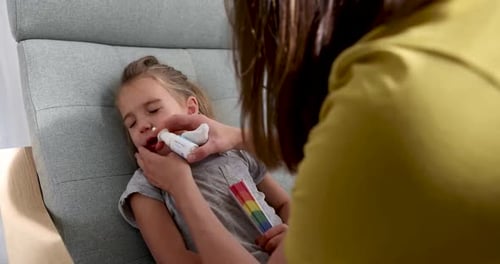 Child Receives Nasal Spray from Parent at Home