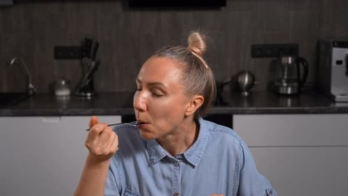 Woman Enjoying a Delicious Homemade Dinner in Her Kitchen Relaxed Slow Eating