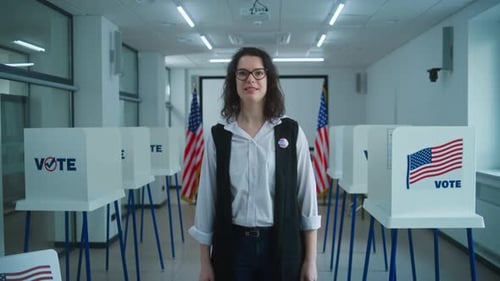 American Female Citizen with Badge Speaks on Camera at Polling Station