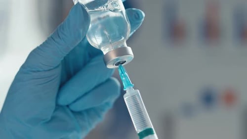 Medical Professional Drawing Liquid From Vial With Syringe