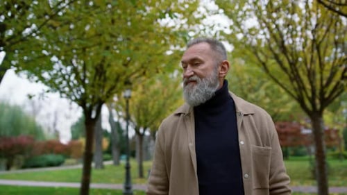 Portrait of Confident Man Walking in Beautiful Autumn Park. Good Looking Male