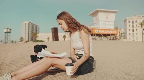 Woman Enjoys Beachside Snack with Dog