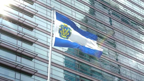 Flag Waving with Coat of Arms in Front of Modern Corporate Building