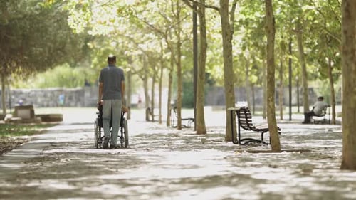 Man Pushing Woman in Wheelchair in Slow Motion